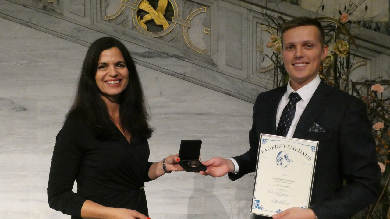Nina Solli deler ut fagprøvemedalje til Hans Vegar Danielsen i IKT – servicefaget