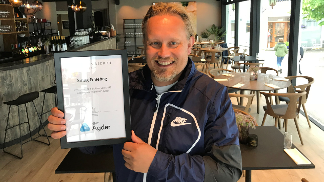Hans Petter Klemmetsen holder opp diplomet som viser at Smag & Behag er kåret som Månedens bedrift i juli 2018 av NHO Agder.