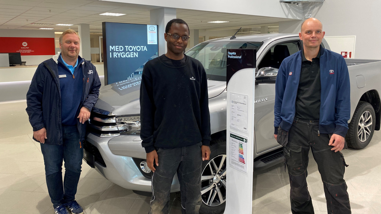 Mark-Anthony Atepo i Toyota-butikken sammen med salgssjefTom Fossen (t.v) og teknisk leder Gøran Skogstad (t.h).
