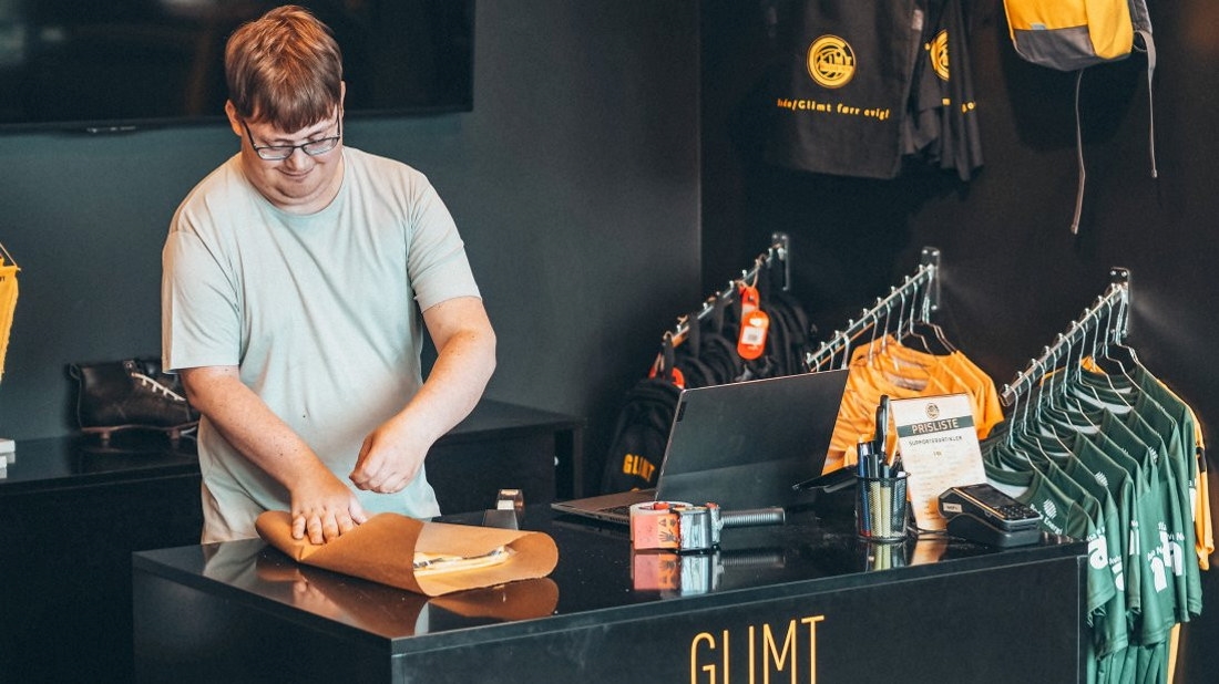 John-Håkon Nybakks glade ansikt og smittende humør er det første som møter folk i Glimt-shop på Aspmyra.